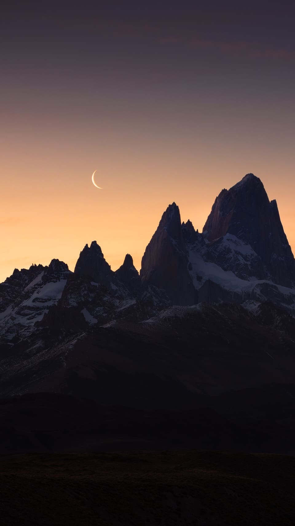 Crescent moon behind Cerro Torre and Fitz Roy at dusk